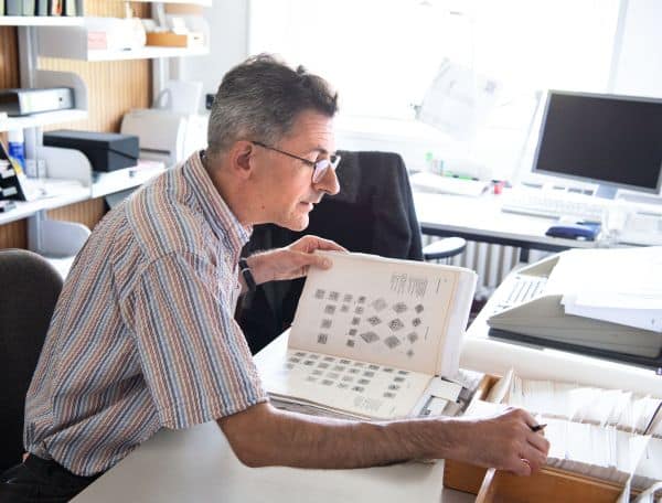 Ein Mann sitzt in einem Büro und schaut in seine Unterlagen